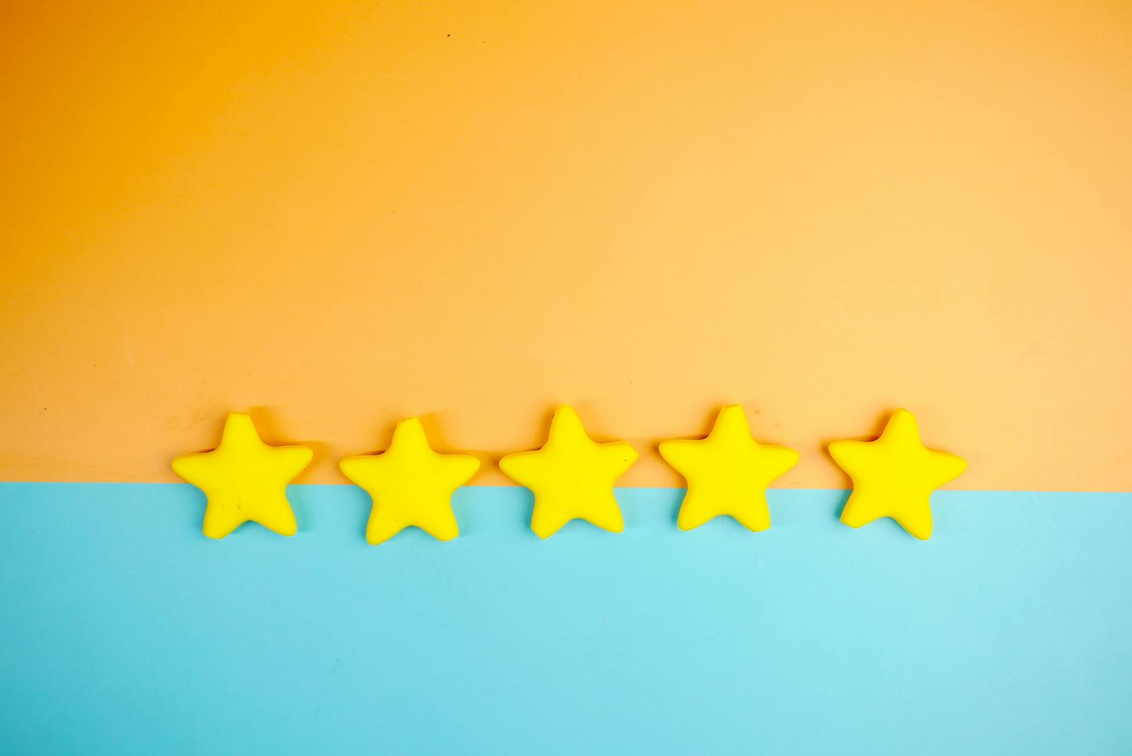 Bright yellow stars arranged on a vivid orange and blue background with copy space.