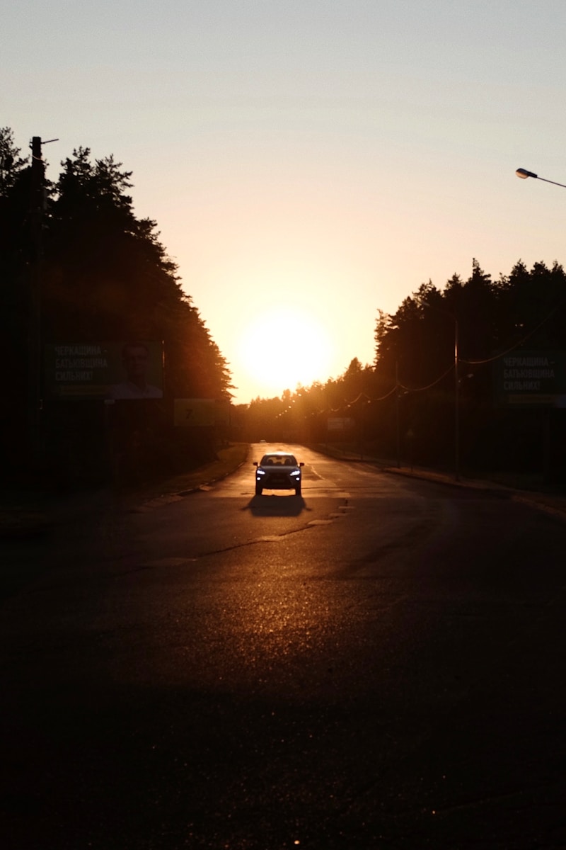 a car driving down a street at sunset