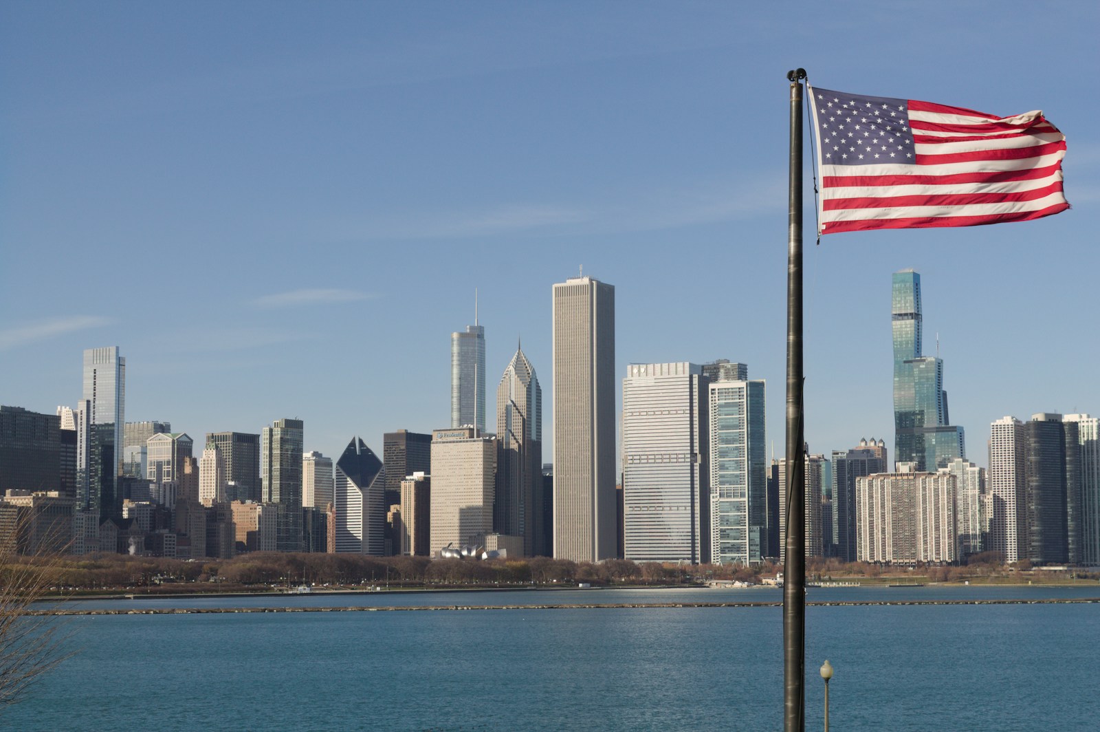 An american flag flying in front of a city skyline